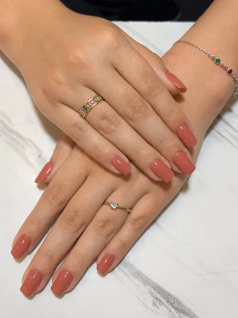 Mesmas mãos com alongamento e esmaltação coral